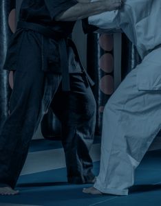 Close-up of two people practicing Brazilian Jiu-Jitsu, one in a black gi and the other in a white gi