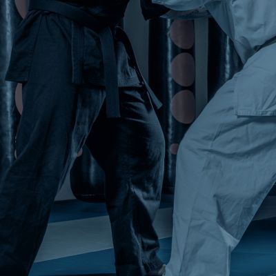 Close-up of two people practicing Brazilian Jiu-Jitsu, one in a black gi and the other in a white gi